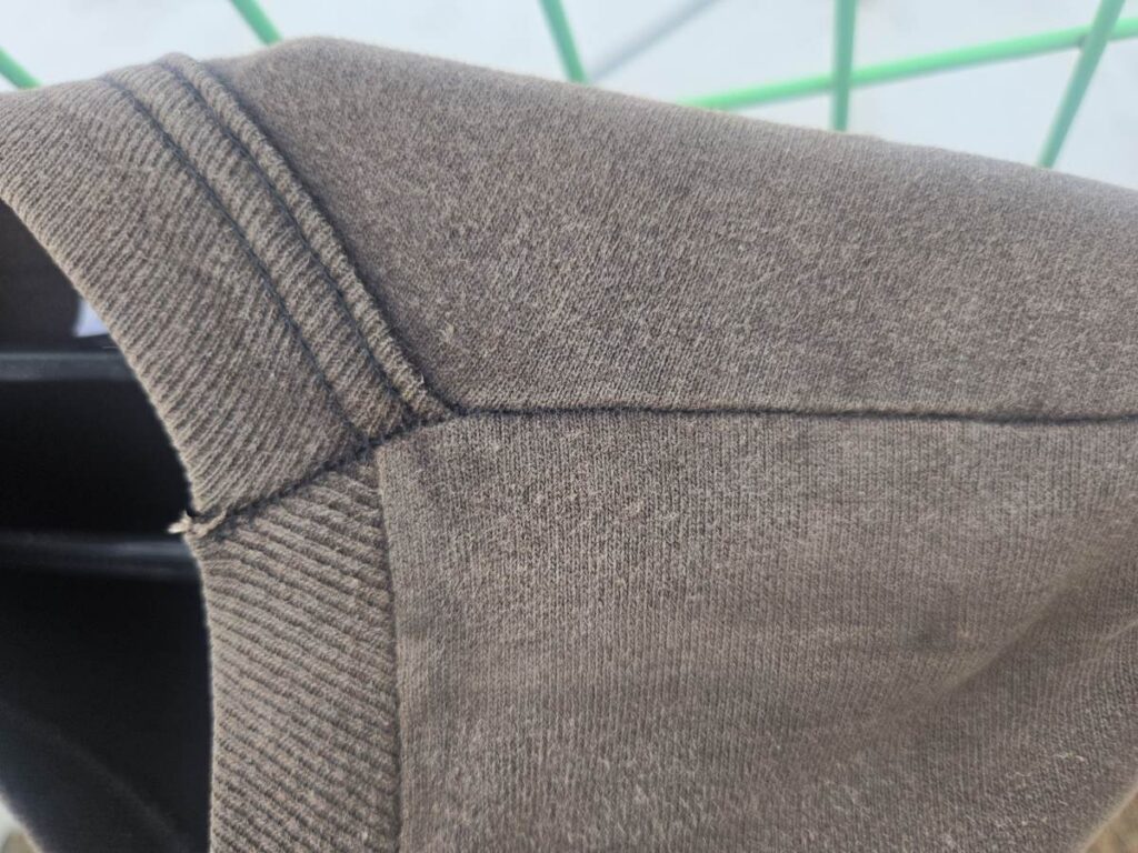 바랜 원단 위에 검정을 유지하고 있는 어깨 봉제선의 실